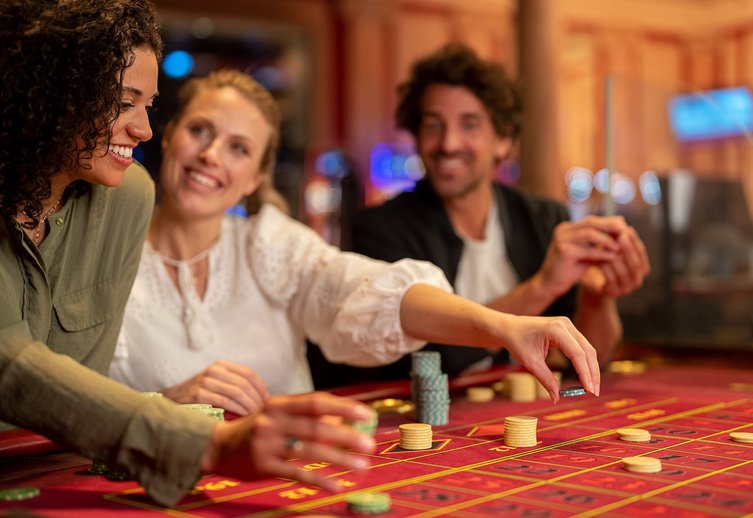 Two women and a man at the roulette table